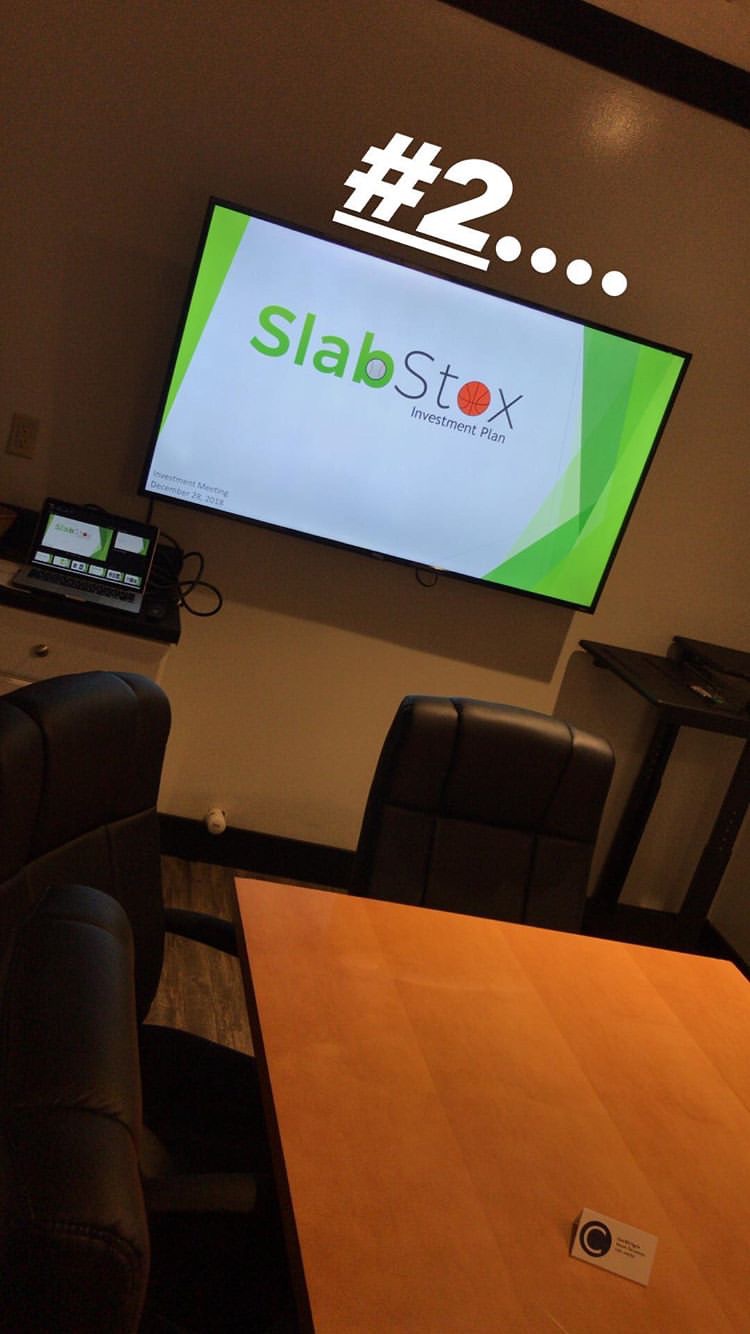 Image of SlabStox logo on a TV in a conference room