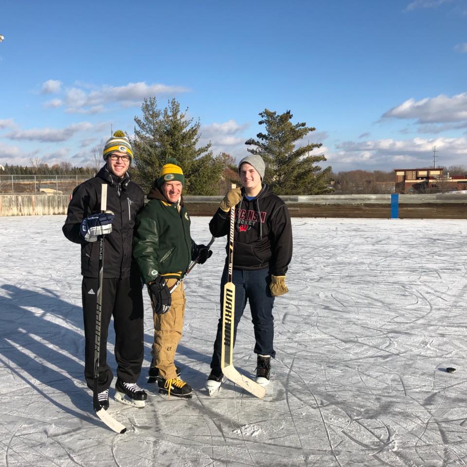 Photo of SlabStox founder Aaron Nowak and two family members on an ice rink, wearing ice skates and holding hocket sticks
